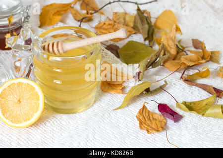 Voll frischem Honey Pot und Honig Stick mit Sommerblumen auf rustikalen Holztisch, selektiver Fokus Stockfoto