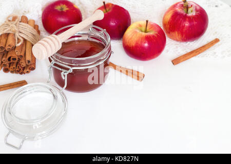 Honig im Glas und Apple mit Zimtstangen auf weißem Hintergrund Stockfoto