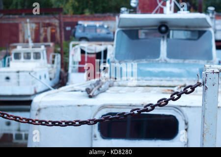 Alte rudern Fischerboote sind gebunden und Marooned mit Ketten an den Fluss Ufer. Stockfoto