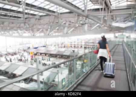 Bangkok, Thailand - 8. August 2017: verschwommenen Hintergrund der asiatischen Frau ziehen Koffer zu Fuß durch das Tor am Suvarnabhumi Flughafen. Die Population Stockfoto