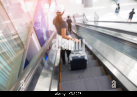 Bangkok, Thailand - 8. August 2017: verschwommenen Hintergrund der asiatischen Frau mit Gepäck Koffer auf rolltreppen am Suvarnabhumi Flughafen. Die beliebtesten se Stockfoto