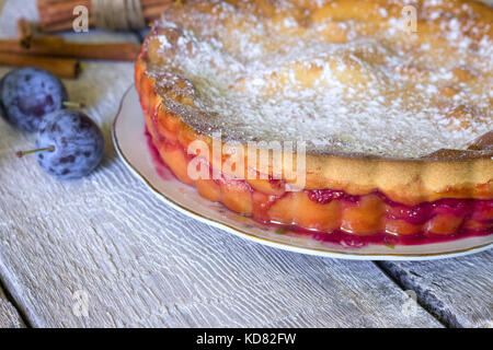 Pflaumenkuchen oder Torte und Pflaumen auf rustikalen Hintergrund Stockfoto