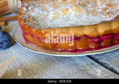 Hausgemachte mürbteig Pflaumenkuchen (pie) im Landhausstil auf hölzernen Hintergrund. Herbst Obst Gebäck bröckeln.. Stockfoto