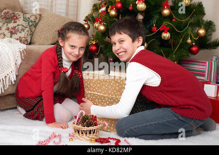 Kind in Santa hat Spaß und Spielen, Geschenke, Weihnachten Dekoration zu Hause, glücklich, Emotion, Winterurlaub Konzept Stockfoto