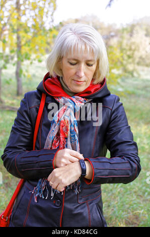 Eine Frau mit einem Fitness Armband ihre Gesundheit Daten zu lesen. Stockfoto