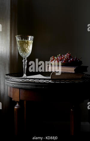 Weißwein auf einem Tisch vor dunklem Hintergrund. Stockfoto