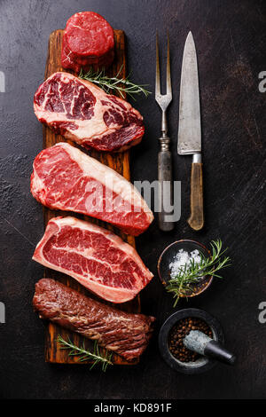 Vielzahl an Raw Black Angus Prime Fleisch steaks Filet Filet Mignon, Rib Eye, Roastbeef, Blade, Machete auf Holzbrett und Gewürzen Stockfoto