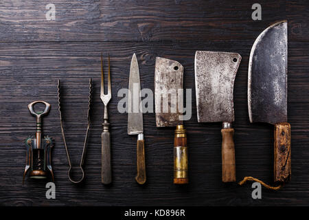 Vintage Metzger Fleisch Hackmesser, Korkenzieher und Zange auf dunklen verbrannte Holz- Hintergrund Stockfoto