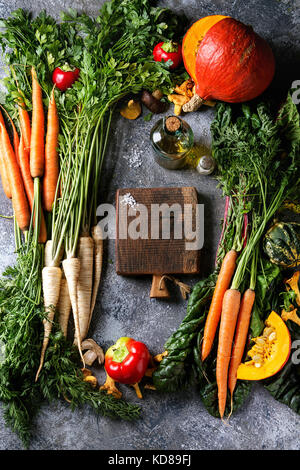 Vielfalt der Herbsternte Gemüse Karotte, Pastinak, Mangold, Paprika, hokkaido Kürbis, Pilze. Leere Holzhackbrett, Olivenöl, Salz über g Stockfoto