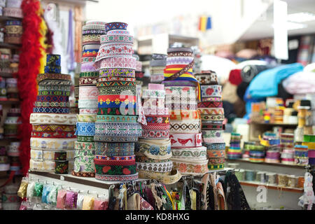 Verschiedene farbige Rollen mit Stickerei Textilien traditionell auf eine Tabelle aus Basar eingerichtet. Stockfoto