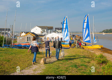 Suffolk Coastal Path, Leute, die ihre Hunde entlang der Küste an der Mündung des Flusses Deben Ansatz der Felixstowe Ferry Segelclub, Großbritannien Stockfoto