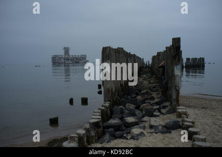 Blick auf die Ostsee von Schuhen Doły in Polen. Im Hintergrund rund 100 Meter vom Ufer entfernt ist ein verfallenes Nationalsozialismus deutsche U-pen Stockfoto