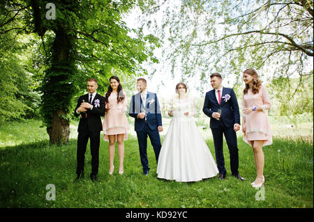 Hochzeit paar, Brautjungfern und groomsman Warten auf bester Mann, um eine Flasche Champagner in einer atemberaubenden Natur Ecke geöffnet. Stockfoto