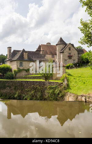 SEGUR-LE-CHATEAU, Frankreich - 30. JUNI 2017: Blick über den Fluss Auvezere zu einem malerischen mittelalterlichen Teil des Dorfes im Sommer Sonne läuft. Stockfoto