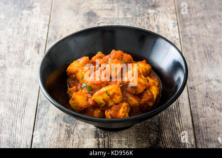 Chicken Tikka Masala in schwarz Schüssel auf hölzernen Tisch Stockfoto