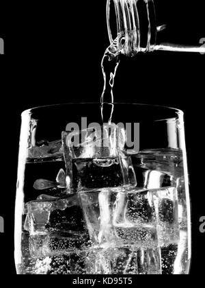 Flasche Soda Mineralwasser Gießen in Glas Stockfoto