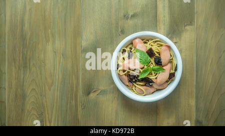 Spaghetti mit Wurst und getrocknete Paprika, scharf auf hölzernen Hintergrund, Ansicht von oben Stockfoto