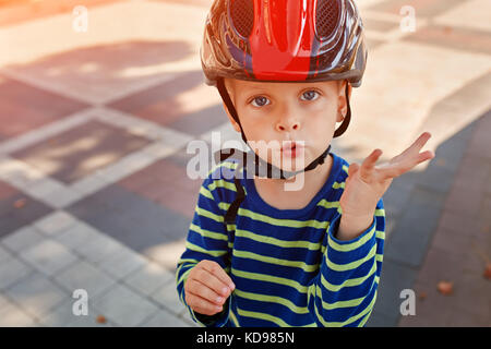 Kind mit einem Helm lacht glücklich am Park. closeup Stockfoto