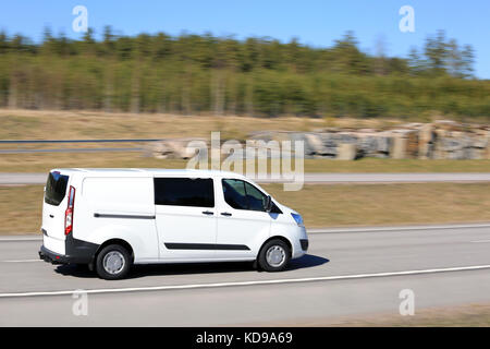 Leere Autobahn an einem schönen Frühlingstag mit weißen Van an Geschwindigkeit, verschwommenen Hintergrund mit in die Kamera schwenken. Stockfoto