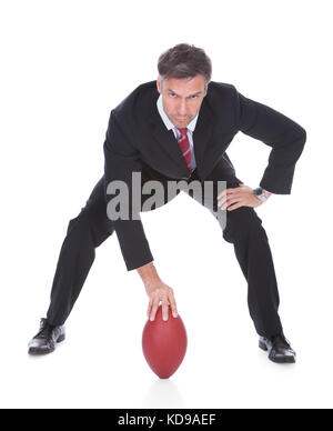 Portrait von Reifen Geschäftsmann bereit, American Football zu spielen Stockfoto