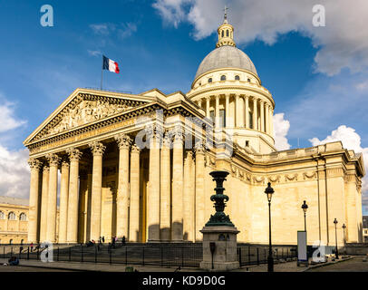 Dreiviertelblick auf das Pantheon in Paris bei Sonnenuntergang mit der französischen Flagge im Wind. Stockfoto