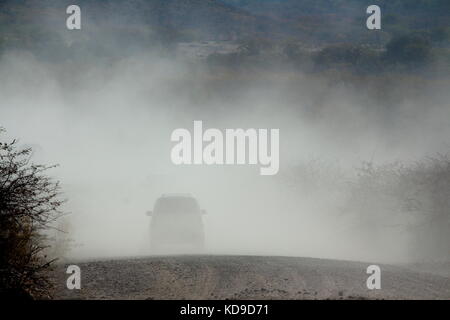 Ein paar der 4x4-Fahrzeugen, die in einem staubigen Wüste Straße in Namibia fahren Stockfoto