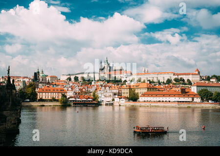 Prag, Tschechische Republik. Schiff segeln entlang der Moldau auf dem Hintergrund der Oberen Stadt. das Prager Schloss und der Metropolitan Kathedrale der hl. Vitus, w Stockfoto