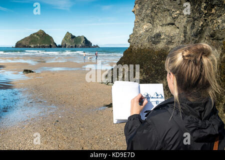 Ein Künstler arbeitet an Holywell Bay - ein Künstler Zeichnung Eine Skizze der ikonischen Gull Rocks in Holywell Bay In Cornwall eine der Poldark-Drehorte Stockfoto