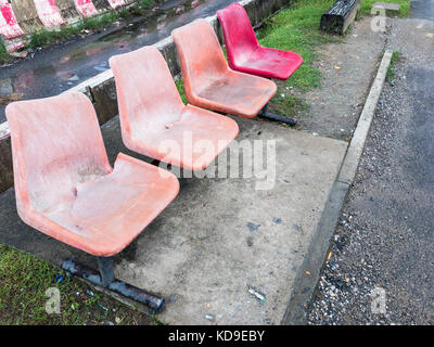 Alten Stuhl aus Kunststoff auf Metall in der Reihe für die Fahrgäste im Bahnhof Plattform nahe der Stadt. Stockfoto