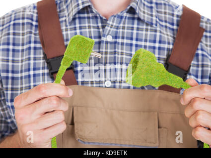 Close-up des Architekten mit Gras bedeckt elektrischen Stecker und Buchse Stockfoto