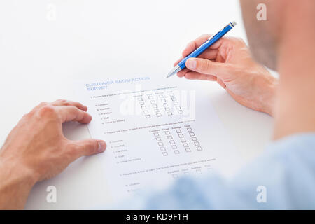 Nahaufnahme einer Person Ausfüllen der Umfrage mit Stift Stockfoto