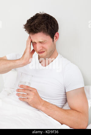 Nahaufnahme Eines Jungen Mannes, Der Medikamente Mit Einem Glas Wasser Einnahm Stockfoto