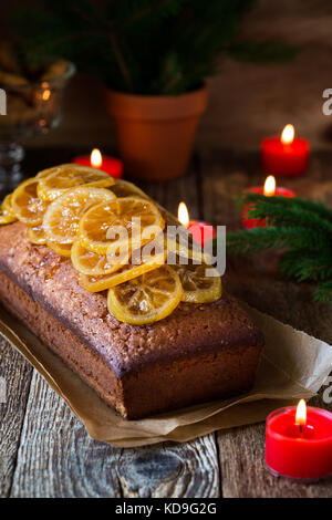 Hausgemachte weihnachten Zitrone Kuchen mit kandierten Früchten auf rustikalen Holztisch gekrönt Stockfoto