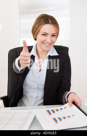 Glückliche junge geschäftsfrau mit Daumen - im Büro Stockfoto