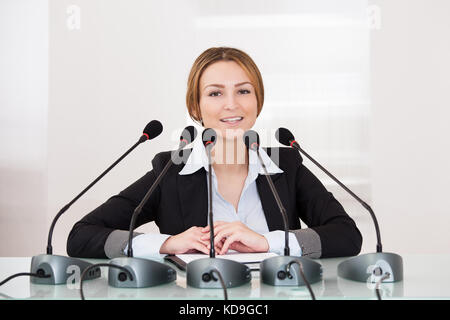 Junge fröhliche Geschäftsfrau, Rede in Konferenz Stockfoto