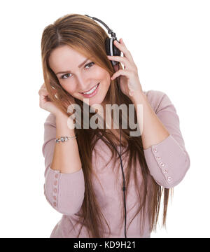 Junge Frau Over White Background Musik über Kopfhörer hören Stockfoto