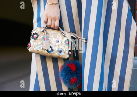 Mailand - 21. September: Frau mit Blumen verziert Beutel, Cartier clou goldenes Armband, weiß und blau gestreiften Kleid vor Fendi fashion show, Mailand Stockfoto