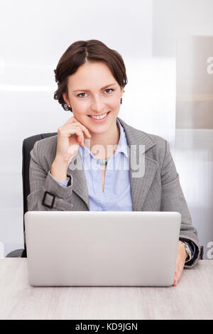 Porträt eines lächelnden jungen Geschäftsfrau Arbeiten am Laptop Stockfoto