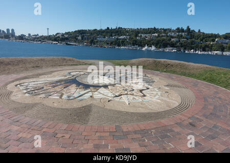 Sculpted analemmatic Sonnenuhr auf Drachenfliegen Hügel; Space Needle im Abstand über den Lake Union in Seattle, Gas funktioniert Park, Seattle, Washington Stockfoto