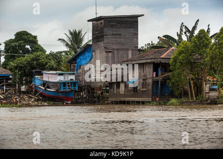 Blick von den Mahakam Fluss an Land mit ungewöhnlichen River Boat und Holz gebaut Struktur für Bird's Nest bewirtschaften. Quelle der Vögel nisten Suppe, Swiftlet Haus Stockfoto