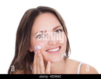 Glückliche junge Frau mit Feuchtigkeitscreme Creme auf Finger Isolated Over White Background Stockfoto