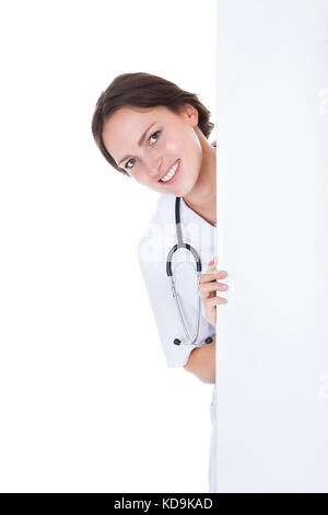 Porträt von glücklich Frau Doktor hinter Plakat Over White Background Stockfoto