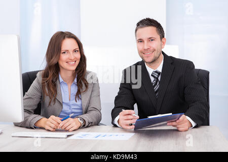 Portrait von Happy business Leute an der Rezeption halten Zwischenablage sitzen Stockfoto