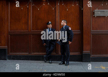 Des pompiers New yorkais discutent devant le O’Haras Pub Restaurant sur Cedar Street est situé en face de la caserne de pompier de Liberty Street, la Stockfoto