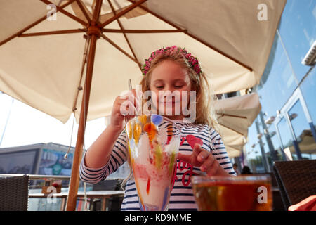 Kleines Mädchen Eis essen im Café im Freien. Stockfoto
