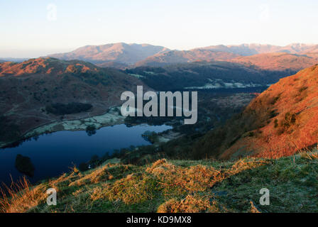 Blick bei Sonnenaufgang vom Aufstieg des NAB Scar über Rydal Water in Richtung Wetherlam, Crinkle Crags und Bowfell, Lake District National Park, Großbritannien Stockfoto