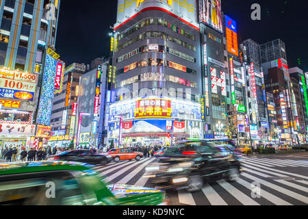 TOKYO - 31. Dezember 2016: Einige Autos sind durch eine vielbefahrene Kreuzung in Shinjuku district in der Nacht. Dezember 31, 2016 Shinjuku ist ein spezieller wa Stockfoto