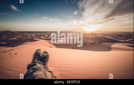 Ein Mann genießt den Sonnenuntergang in den Dünen in der Wüste Sahara - Merzouga - Marokko Stockfoto