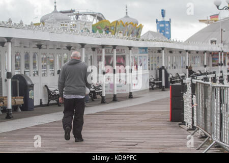 Brighton Sussex. 11. Oktober 2017. Ein Mann Spaziergänge auf den Brighton Pier während blustery und windigen Bedingungen als die Überreste Hurrikan nate ab Mitte der altlantic wird erwartet, Teig Teilen Großbritanniens Credit: Amer ghazzal/alamy leben Nachrichten Stockfoto