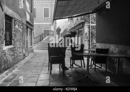 Venedig, Italien. 11. Oktober, 2017. (Bilder in Schwarz und Weiß übernommen wurde) eine Frau wird ein Restaurant am Morgen mit Nebel in Venedig, Italien. In diesem Zeitraum in Venedig beginnt der erste neblige Morgen. © Simone padovani/Erwachen/alamy leben Nachrichten Stockfoto